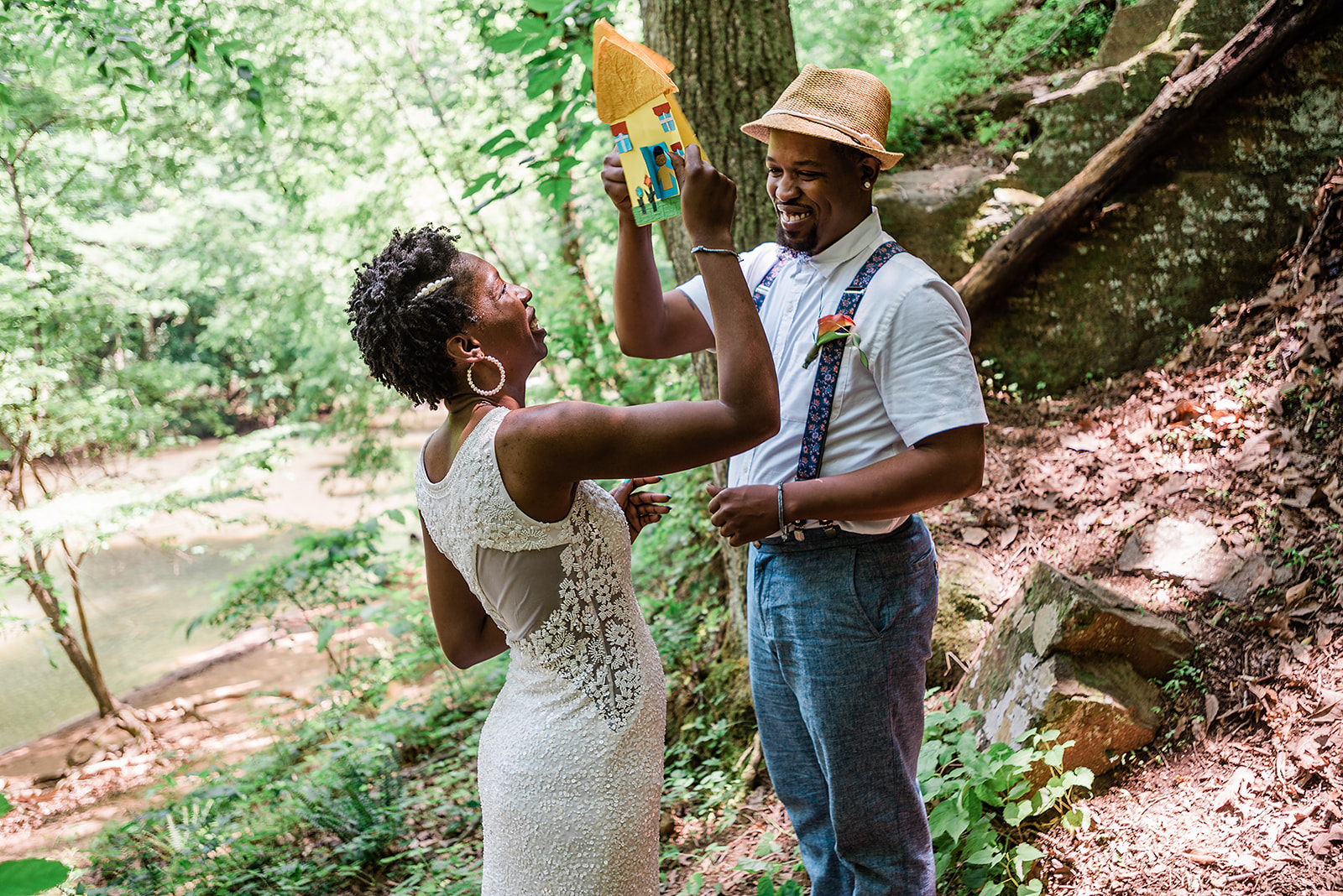 couple "high fives" with their handmade vow cards during their adventure elopement