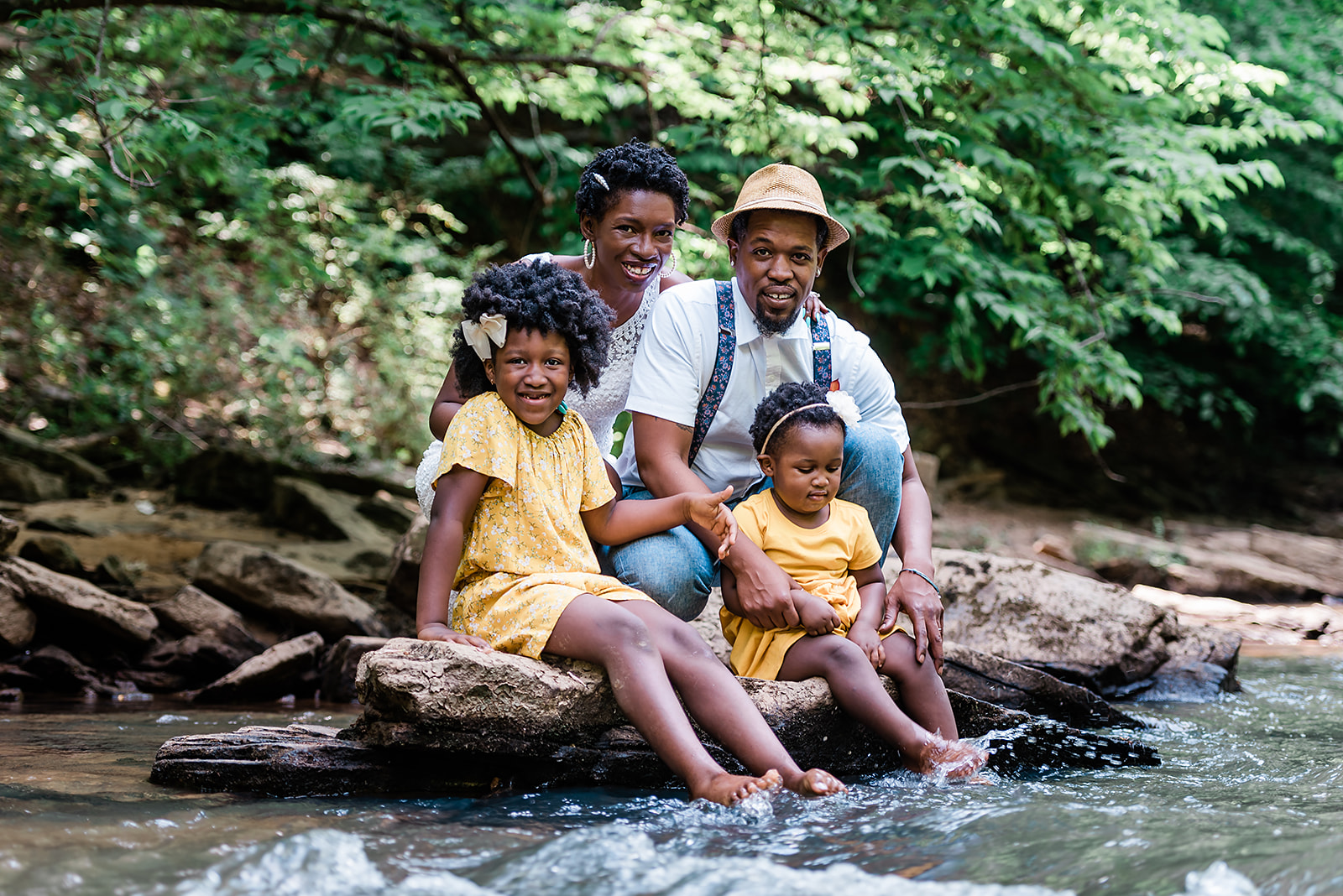 Family smiles for the camera while sitting creekside at their adventure elopement