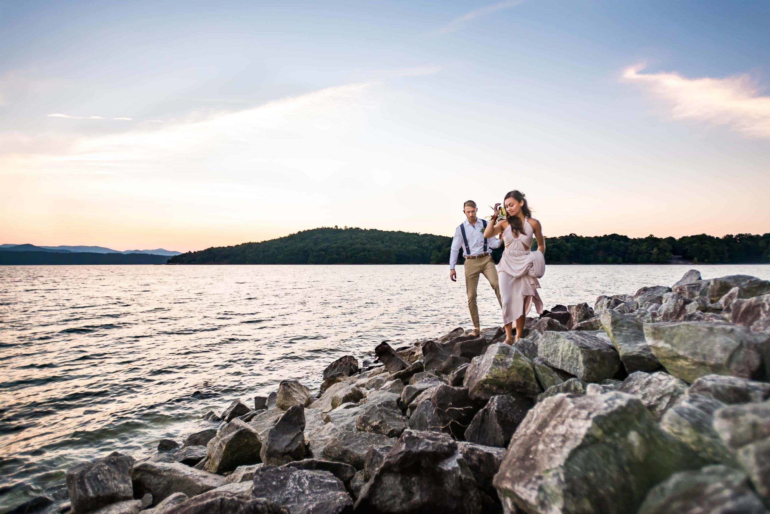 Couple explores the rocky shore at their elopement, a wedding type you can customize to be fully your own!