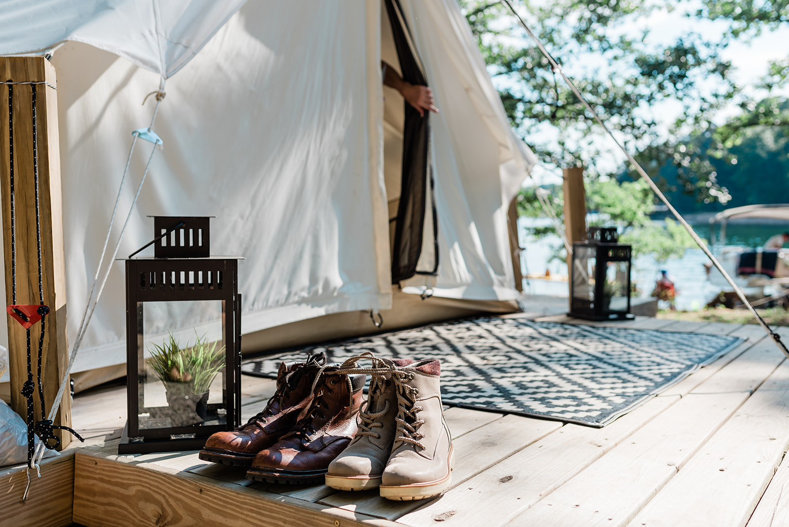 in getting ready for a Glamping Elopement, two pairs of hiking boots sit on the platform of a glamping tent in Georigia. A canvas tent is in the background