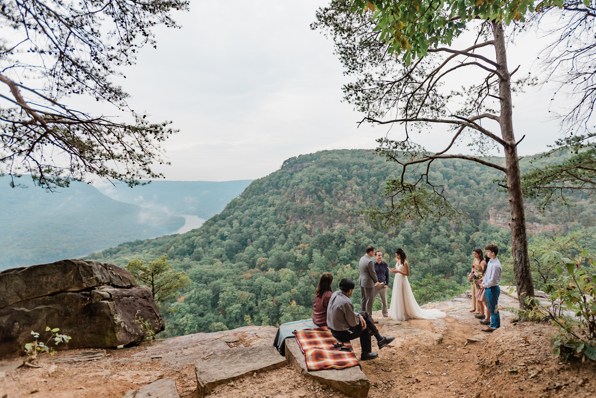 This is a picture of an elopement ceremony on a cliffside in Chatanooga. You can see the bride and groom and their crew.