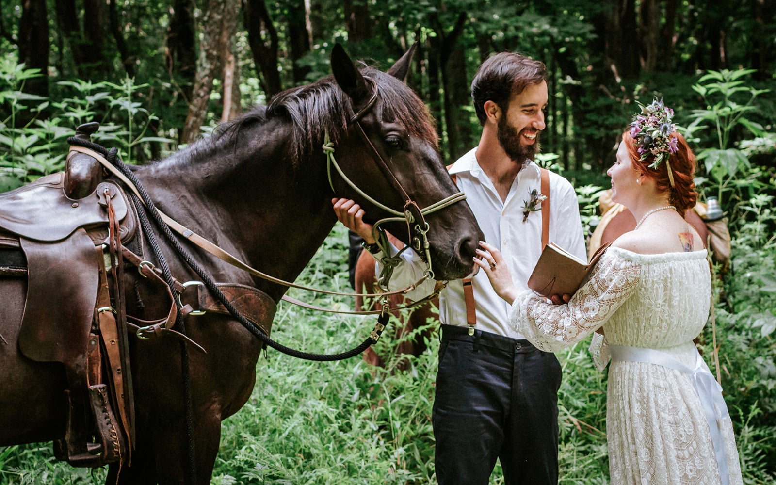 This is a picture of a bride and groom sharing their vows in the forest and being interrupted by a horse.