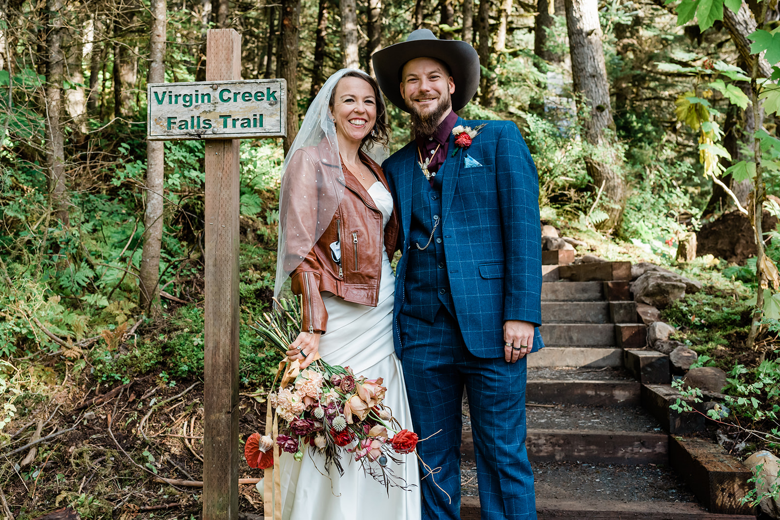 This is a picture of a bride and groom smiling at the camera in the woods. This was taken during their family elopement. Eloping with family can work for you!