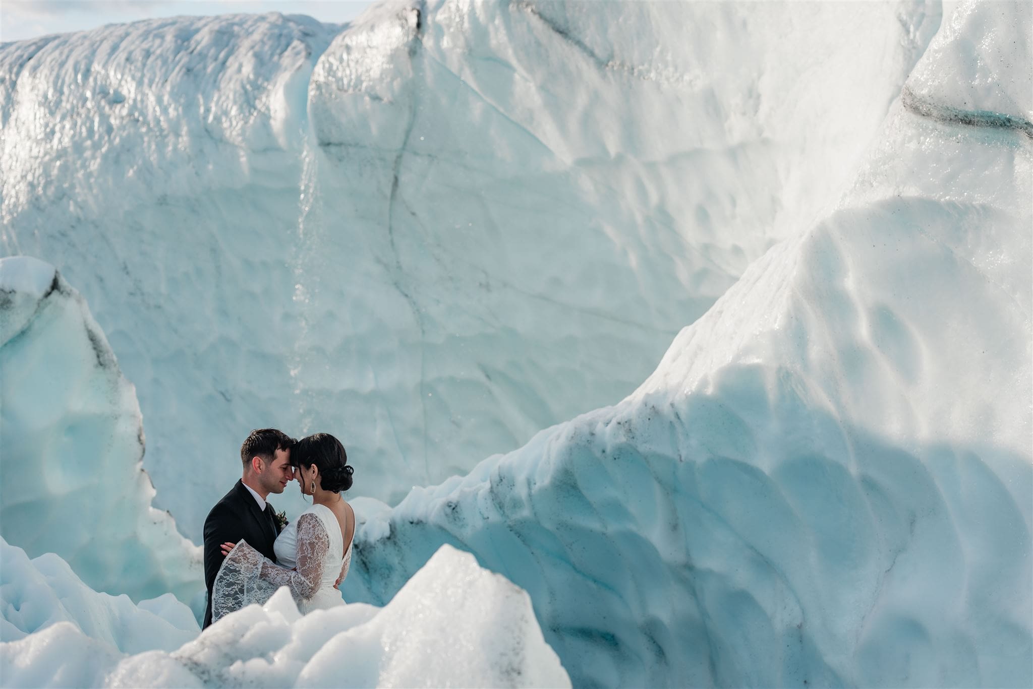 This is a picture of a bride and groom exploring icebergs during their elopement experience.