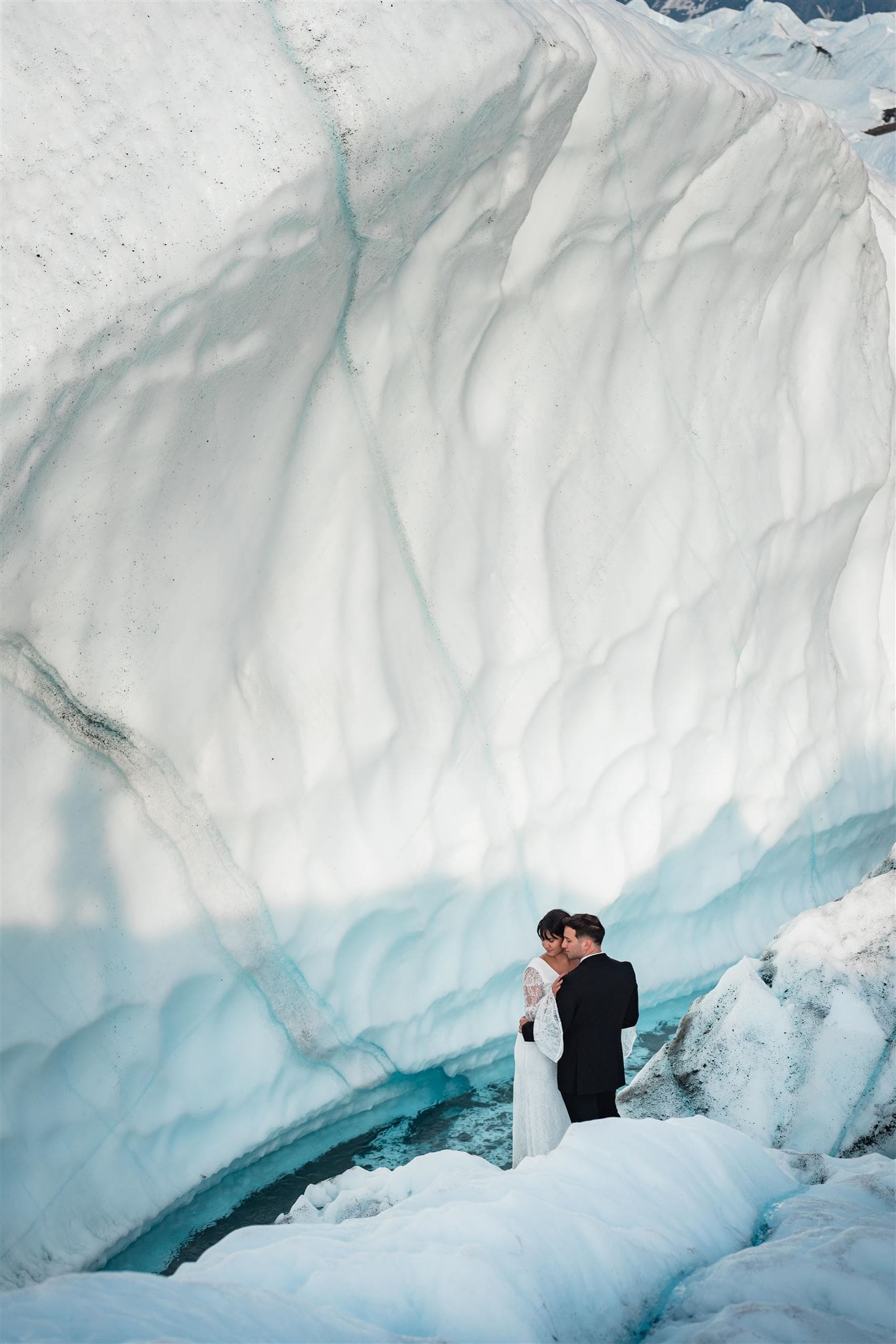 This is a picture of a bride and groom exploring icebergs during their elopement experience.