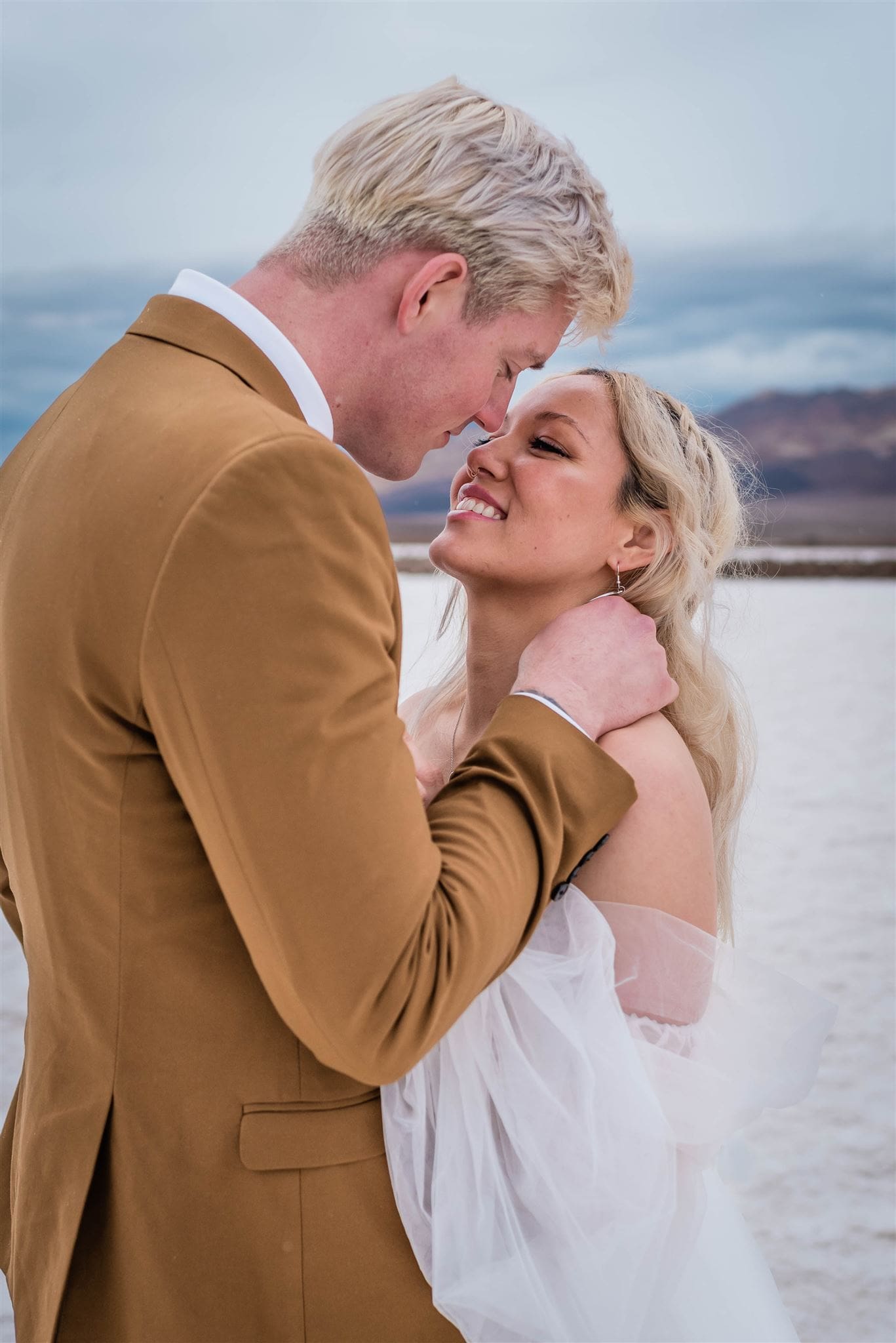 This is a picture of a bride and groom saying their vows on the salt flats. They are all alone and enjoying their solitude time together.